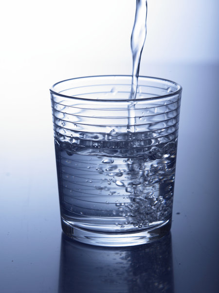 Ein Glas wird mit Wasser befüllt